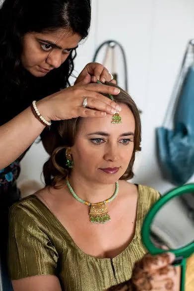 Makeup artist styling wedding guest before special event