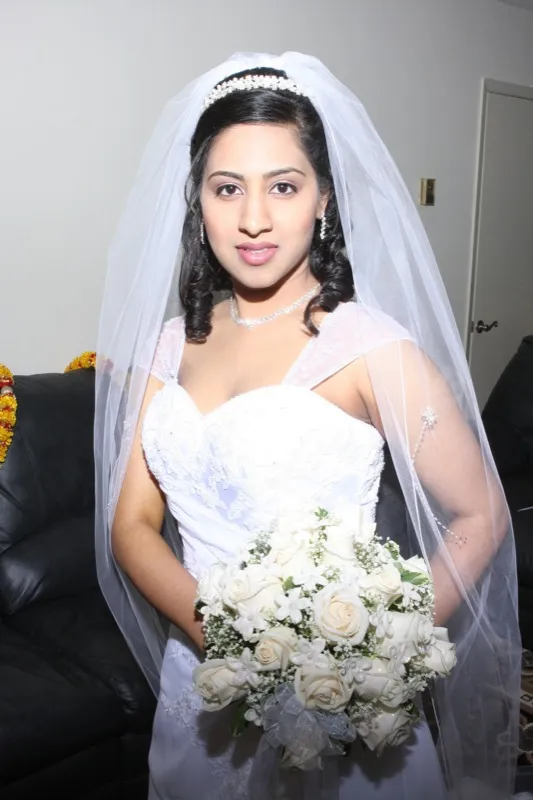 Bride in white wedding gown holding bouquet with professional bridal makeup