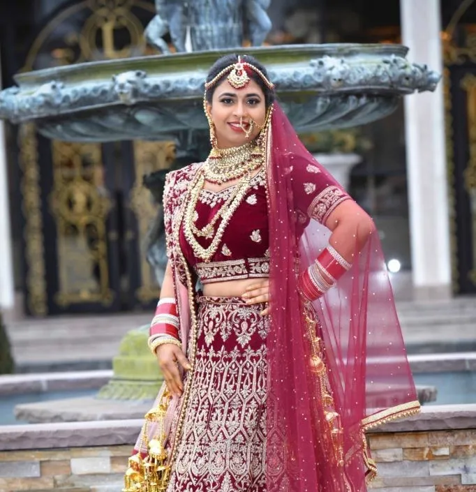 Bride in red bridal lehenga with professional wedding makeup