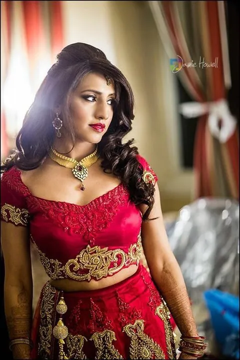 Bride wearing red bridal outfit with glamorous wedding makeup